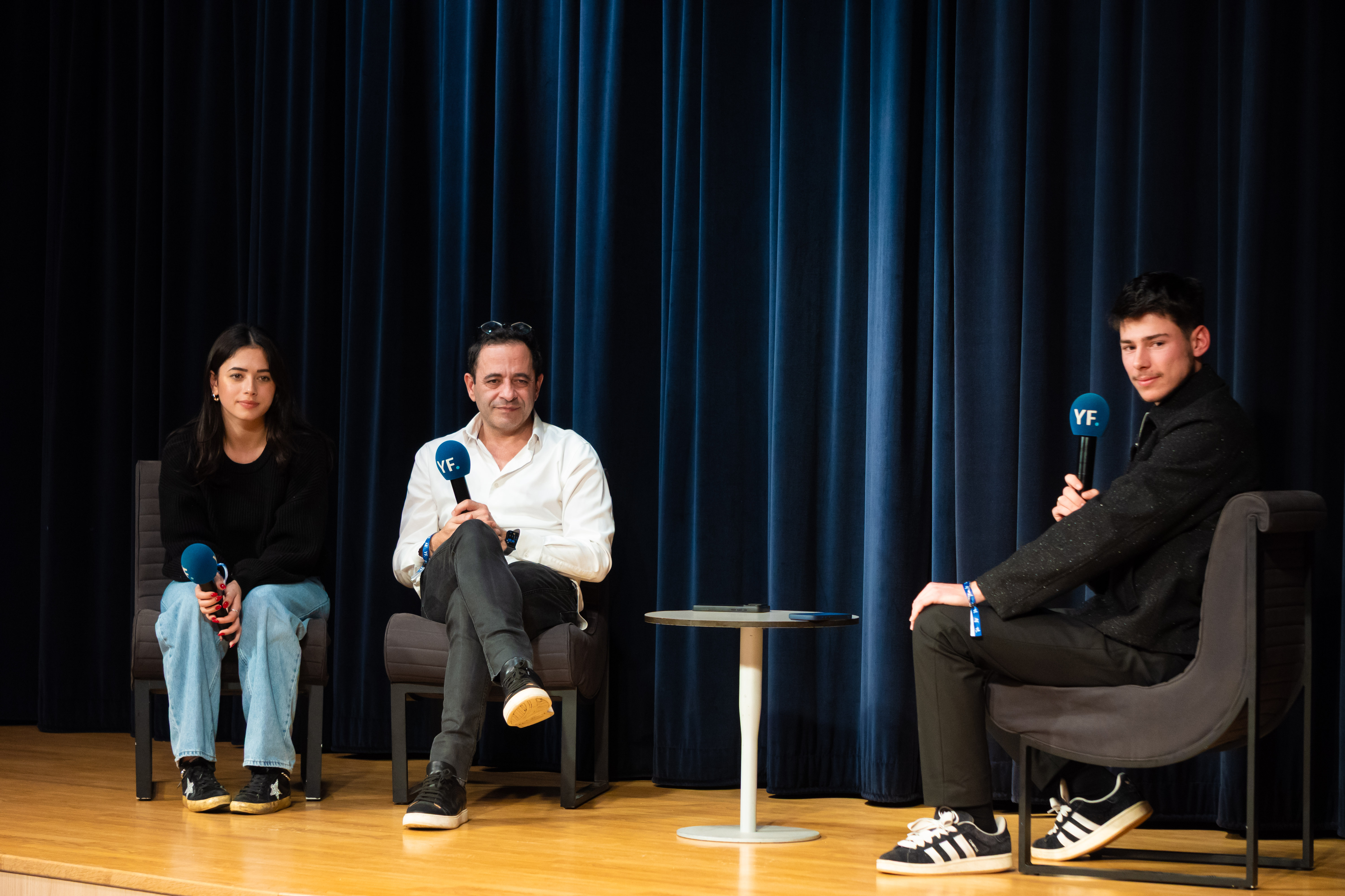 Le plateau du salon Your Future : trois intervenants en tribune, devant un rideau bleu